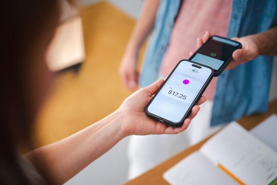 A person completes a digital purchase by tapping their smartphone against a merchant device. This contactless transaction facilitates a quick and secure payment.