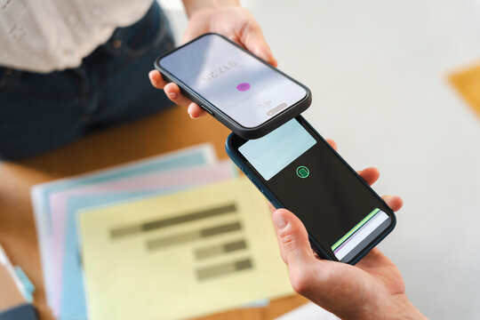 A customer completes a transaction by tapping their phone against a business owner device. This contactless payment method allows for fast and secure daily business.