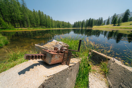 Ancien m&eacute;canisme de vanne rouill&eacute; au bord d'un lac de montagne, Queyras