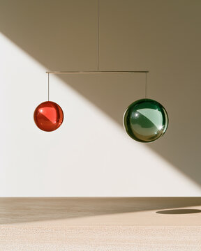 Abstract Spheres: Two polished, reflective spheres, one a vibrant red and the other a cool green, hang suspended in a minimalist space, casting intriguing shadows on a light-colored wall.