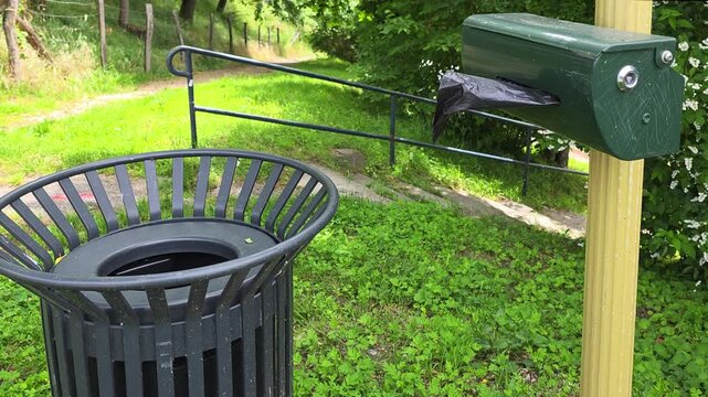 A dispenser for free plastic dog waste bags in the park.
