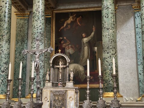 Vilnius, Lithuania - 22 July 2026: View of the interior of Vilnius Cathedral featuring a religious painting above the altar, ornate silver candlesticks, and a crucifix.