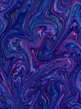 Vibrant blue and purple fluid marble paint swirls captured in a vertical potrait orientation for website backgrounds, digital art projects, and creative print designs.