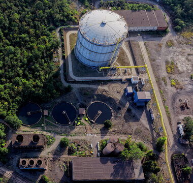 Aerial view of the Smederevo Steelworks featuring a large industrial gas holder, circular water treatment tanks, cooling towers, and piping infrastructure in Smederevo, Podunavlje District, Serbia.