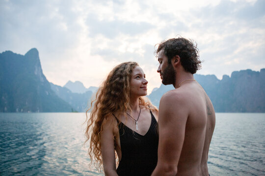 Romantic couple by serene lake.