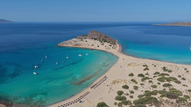 Experience the stunning beauty of Simos Beach on Elafonisos, Greece. Crystal-clear waters and golden sands create a perfect backdrop for sunbathing and leisure activities under the summer sun.