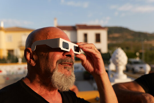 senior man looking solar eclipse with special glasses
