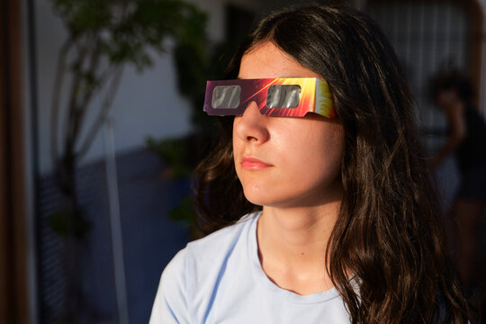 Girl looking solar eclipse with protective glasse