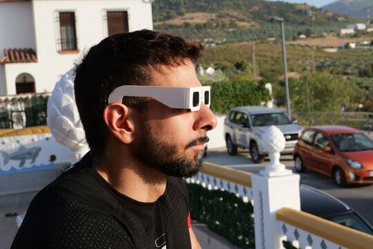 Man looking solar eclipse with protective glasse