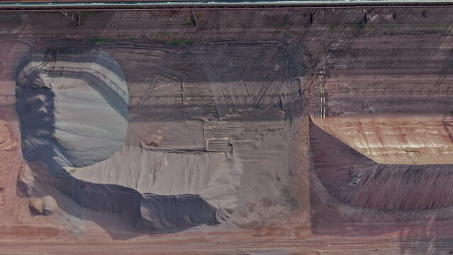 Aerial view of Smederevo Steelworks showing large piles of raw materials, industrial textures, and heavy machinery tracks in Smederevo, Podunavlje District, Serbia.