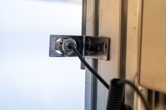 Inductive proximity sensor detecting metal, mounted on industrial automation equipment