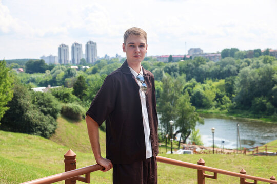 young man wearing brown outfit on a warm sunny summer day outdoors with golden natural light relaxed casual mood.