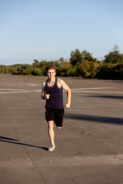 Teenage boy wearing sports clothing running forwards