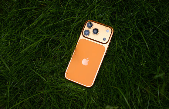 KYIV, UKRAINE - July 10, 2026 : Apple iPhone 17 Pro in Cosmic Orange color on fresh green grass outdoors.