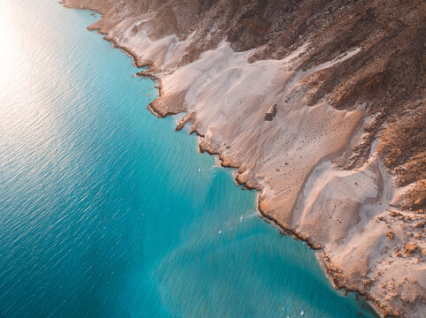 Aerial view of Detwah Lagoon Ramsar Site with white sand dunes meeting the turquoise waters of the Arabian Sea in Socotra, Yemen.