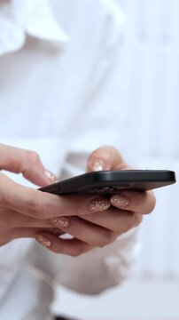 woman holds smart phone in her hands and scrolls through the news feed. Close up of hand uses mobile. point finger on screen, texting text message.	
