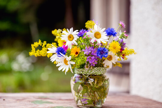 Beautiful bouquet with summer wild flowers and margaritas on green background	