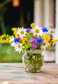 Beautiful bouquet with summer wild flowers and margaritas on green background	