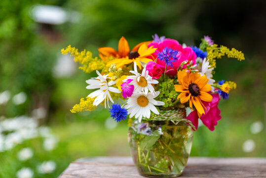 Beautiful bouquet with summer wild flowers and margaritas on green background	
