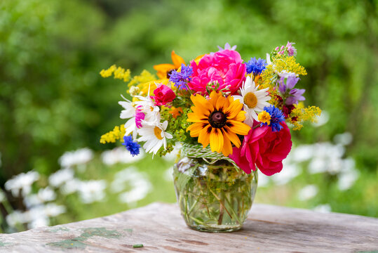 Beautiful bouquet with summer wild flowers and margaritas on green background	