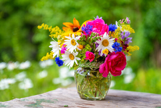 Beautiful bouquet with summer wild flowers and margaritas on green background	