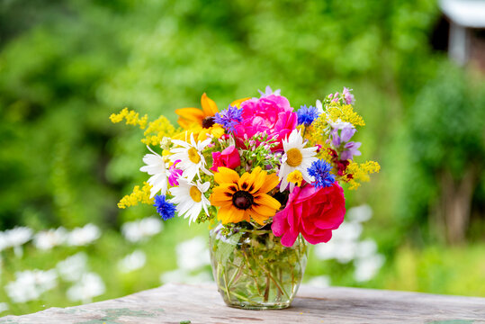 Beautiful bouquet with summer wild flowers and margaritas on green background	