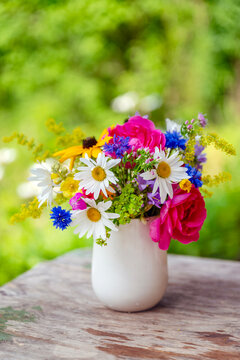 Beautiful bouquet with summer wild flowers and margaritas on green background	
