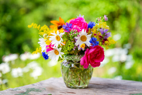 Beautiful bouquet with summer wild flowers and margaritas on green background	