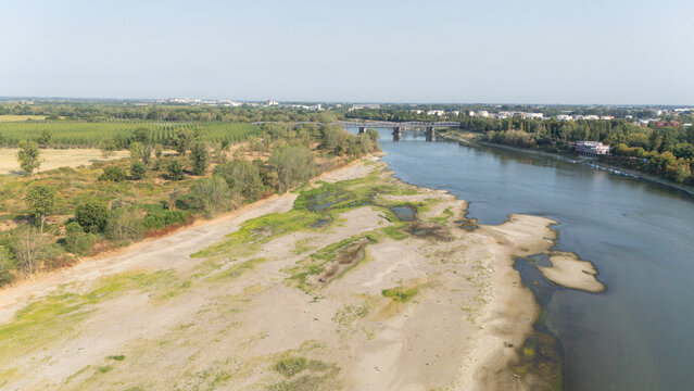 Aerial view of the Po river showing low water levels and exposed sandbanks amidst surrounding farmland in Castelvetro Piacentino, Emilia-Romagna, Italy.