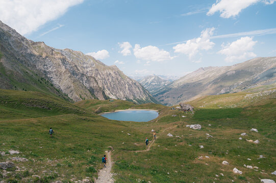 Randonneurs longeant un lac de montagne dans le Queyras