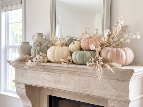 Autumn pumpkins and dried flowers displayed on a stone mantel