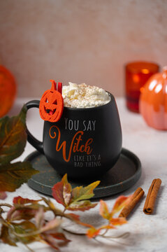 Pumpkin spice latte in black Halloween mug on table