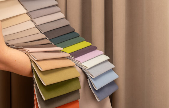 Upholstery fabric swatch fan for custom sofa and curtain. Specialist holding bright textile palette