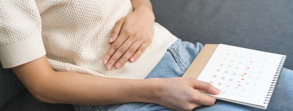Menstruation, periods cycle day of monthly, hurt young woman, girl stomachache, hand holding marking symbol on calendar for missed and delay or late at home. Medical, healthcare, gynecological concept
