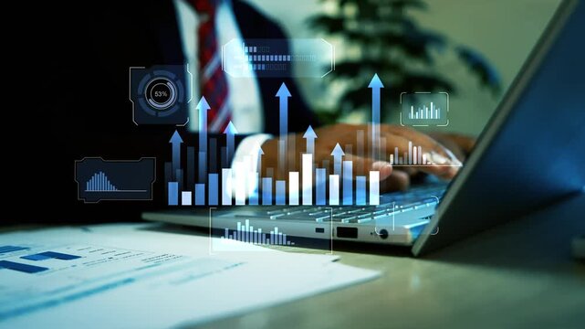 Businessman using a laptop with glowing hologram charts and rising arrows above financial reports animation on the screen, Business data growth analytics and digital planning in a modern office