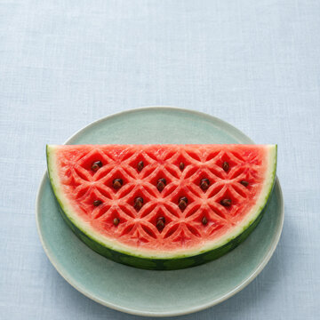 Watermelon slice with intricate carved pattern on green plate refreshing japanese summer food perfect for hot days and healthy eating