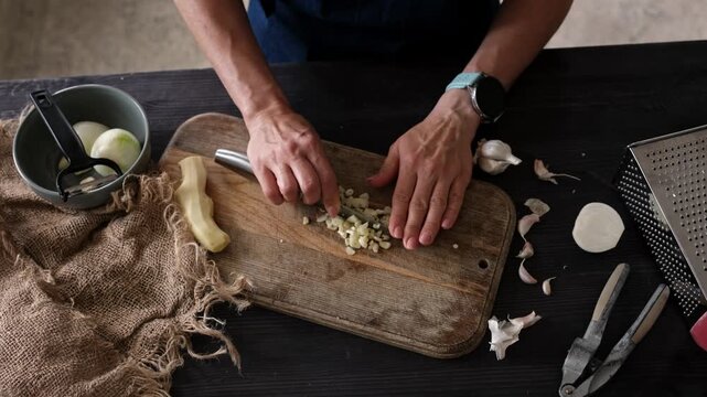 Close-Up Top View Of Woman Slicing Garlic