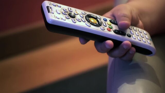 Child Holding TV Remote Control While Watching Television Close Up - 4K