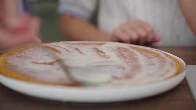 Close-up: pouring cream over golden pancake, tactile texture, 25 fps