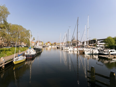 Quiet Marina with Sailboats in Dutch Harbor. Calm waterfront scene with moored yachts and reflections under clear spring skies