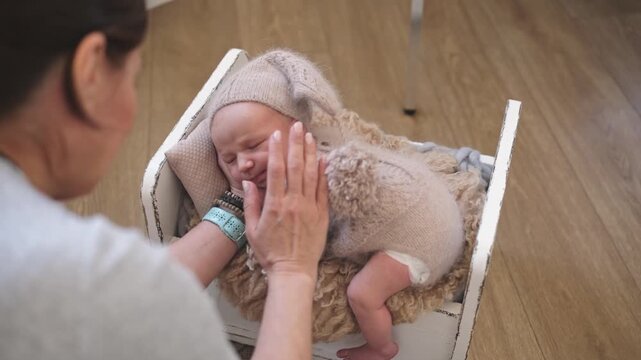 Newborn Photographer Gently Stroking The Baby Backstage At A Photoshoot