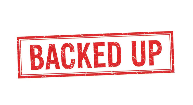A bold red sign with the words 'backed up' written in large, three-dimensional letters, framed by a weathered wooden border