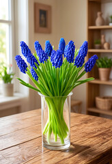 Naklejka premium Spring floral arrangement with blue muscari flowers in a glass vase on a rustic wooden table, home decor and fresh bloom