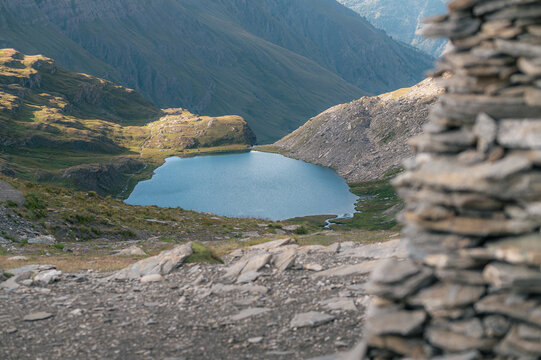 Lac de montagne vu &agrave; travers un cairn de pierres au Queyras