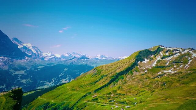 Scenic panorama of Swiss Alps mountains with green valley on sunny day
