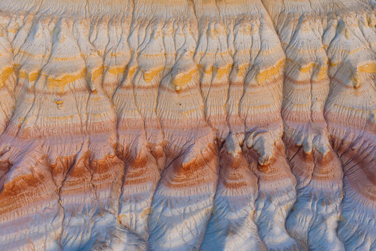 Aerial view of the colorful sedimentary rock formations of Mount Bokty, showcasing intricate erosion patterns and layered strata, Karakiya District, Mangystau Region, Kazakhstan.