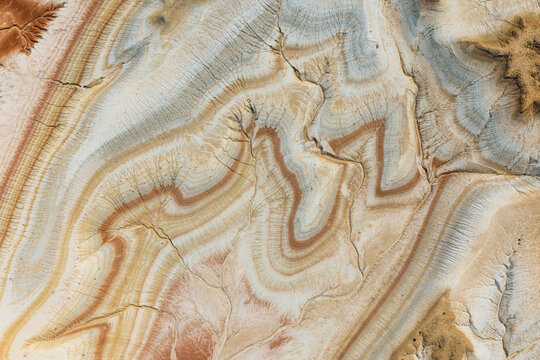 Aerial view of the Tiramisu Hills, showcasing intricate geological layers, colorful sedimentary rock formations, and arid desert textures in Kyzylkum, Mangystau Region, Kazakhstan.