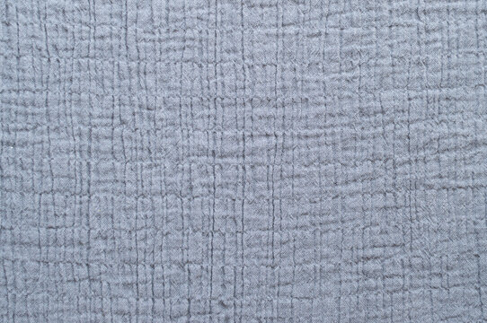 Close-up texture of grey muslin cotton fabric, abstract soft wrinkled textile background
