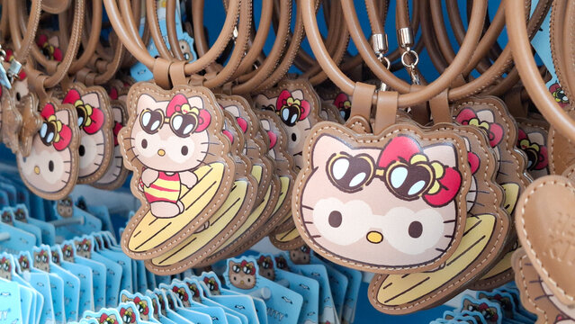 row of Hello Kitty Sanrio brown leather bag charms hanging on display rack featuring summer character design at Terminal 21 Asok Shopping Mall on August 17, 2026 in Bangkok, Thailand.