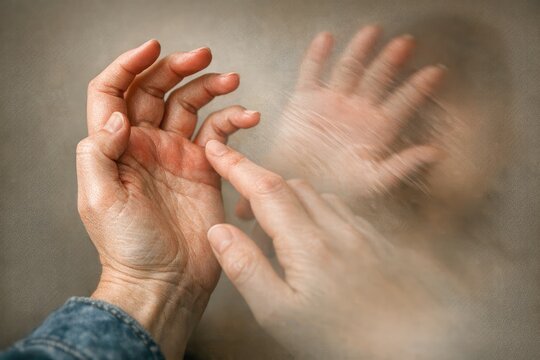 A person lifts their hands upwards, possibly expressing joy or surrender